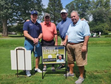 A group of men standing on a golf course